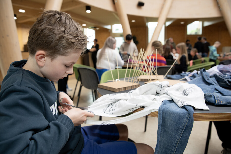 Leerling van OBS de Buttinga knipt strookjes voor zijn kunstwerk